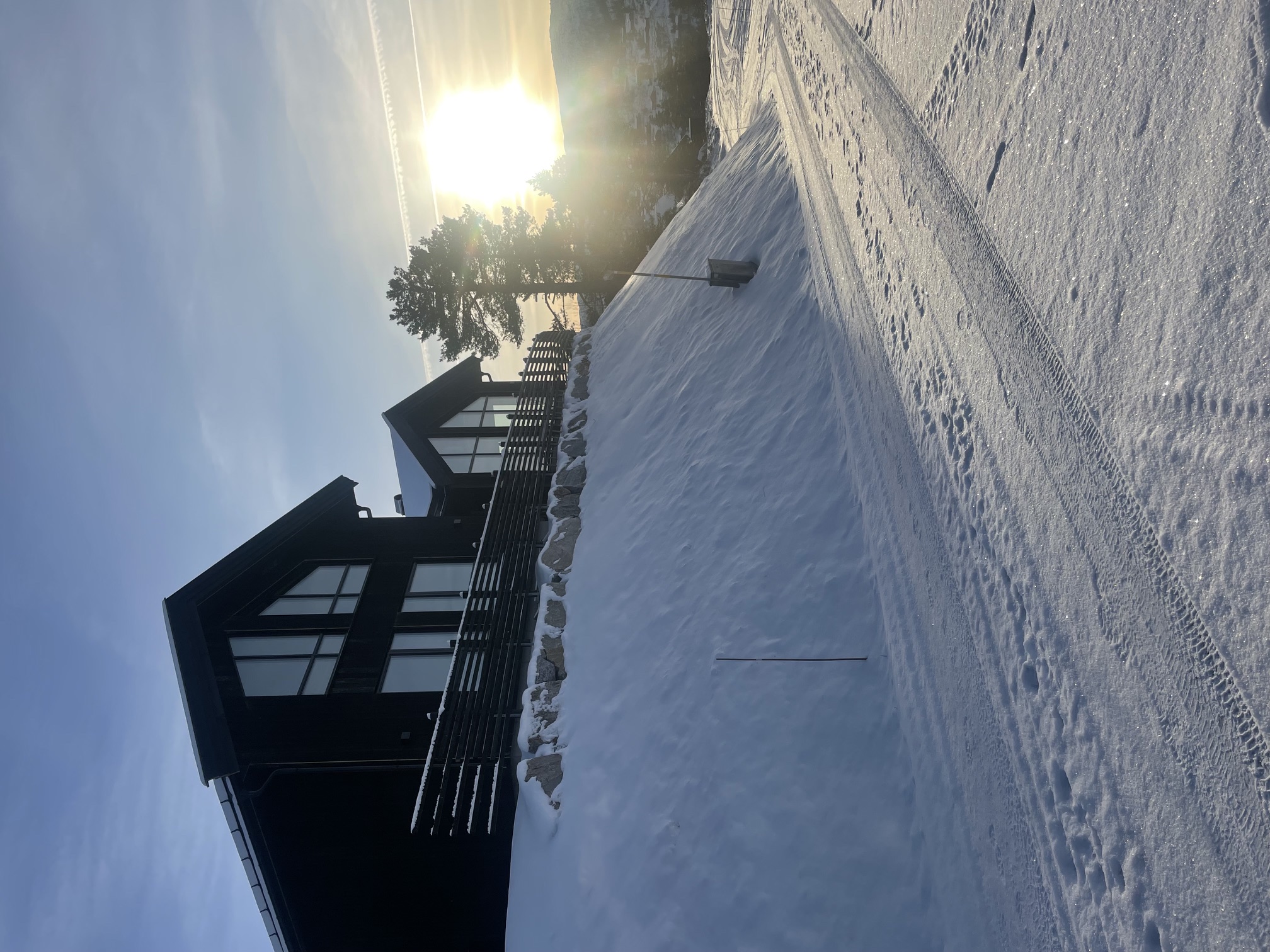 Moderne hytte i snødekt vinterlandskap ved solnedgang
